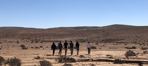 Many people dressed in black walking through the desert. I am proud to be part of the remnant!